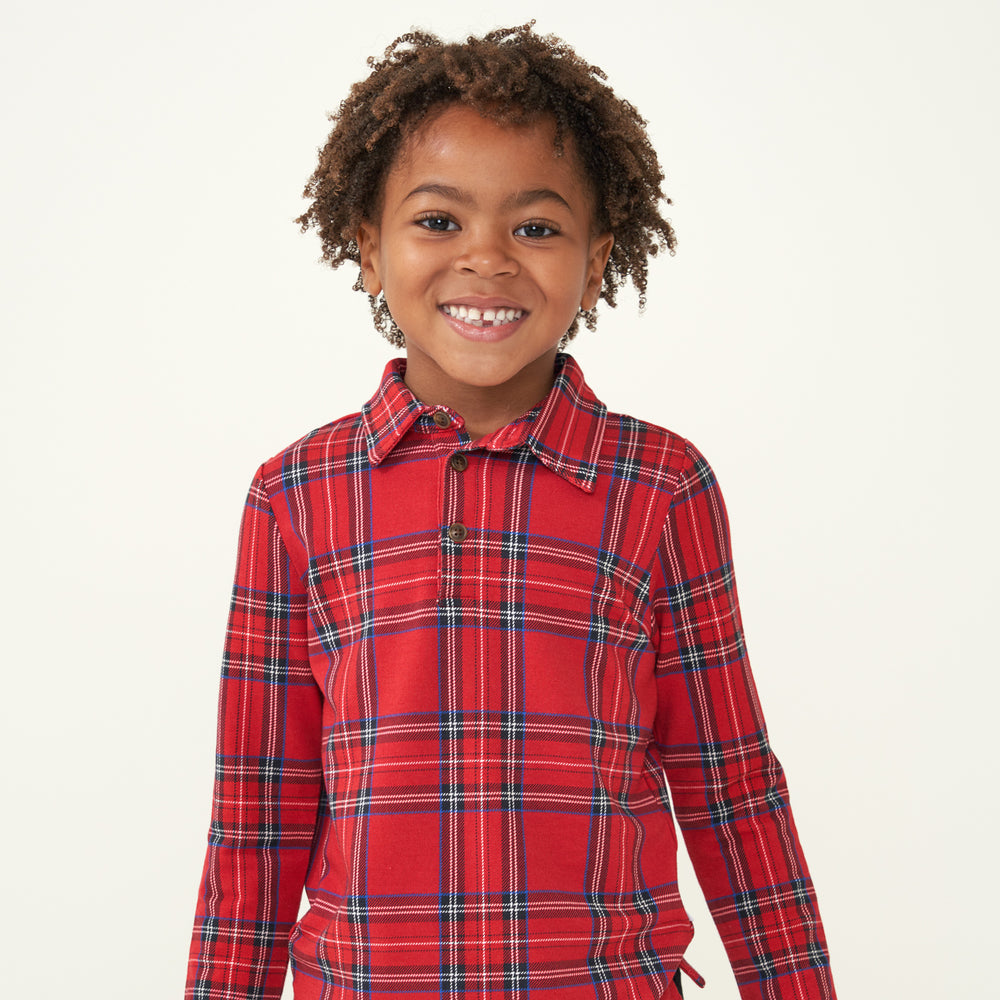 Close up image of a child wearing a Holiday Plaid polo shirt