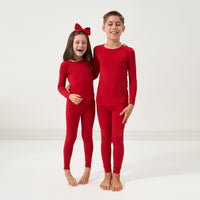 Two children wearing matching Holiday Red two-piece pajama sets