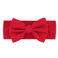 Flat lay image of a Holiday Red luxe bow headband