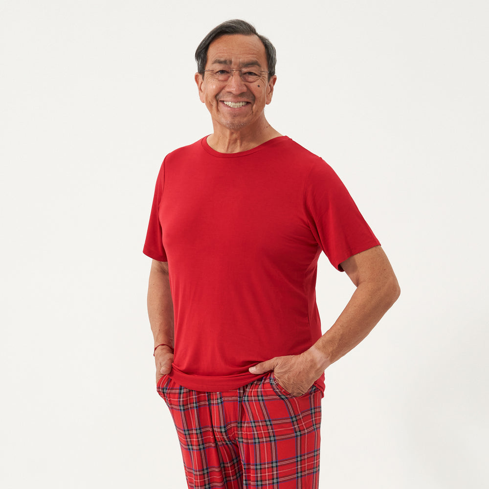 Man with his hands in his pockets wearing a Holiday Red men's short sleeve pajama top and coordinating holiday pajama pants