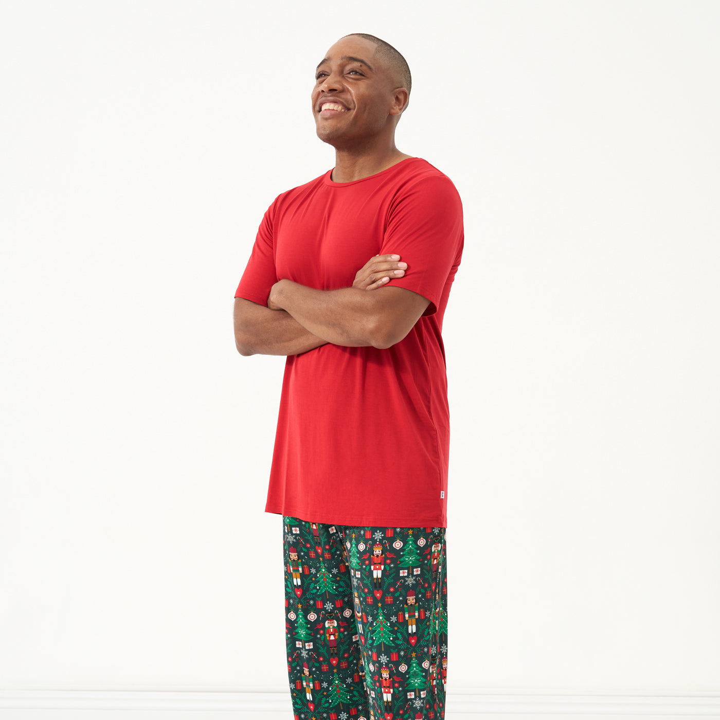 Man with his arms crossed wearing a Holiday Red men's short sleeve pajama top and coordinating holiday pajama pants