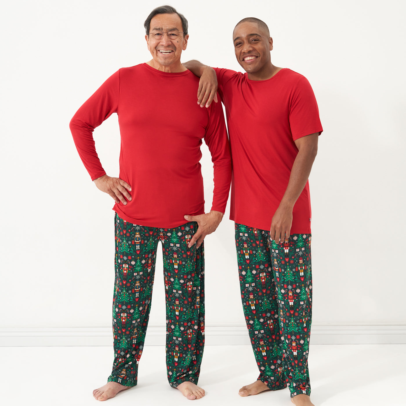 Two men wearing Holiday Red men's pajama tops and coordinating holiday pajama pants