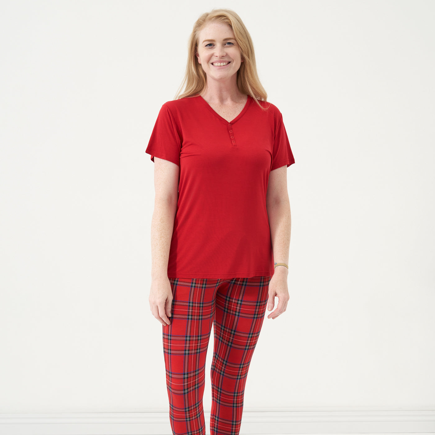 Woman wearing a Holiday Red women's short sleeve pajama top and coordinating pajama pants