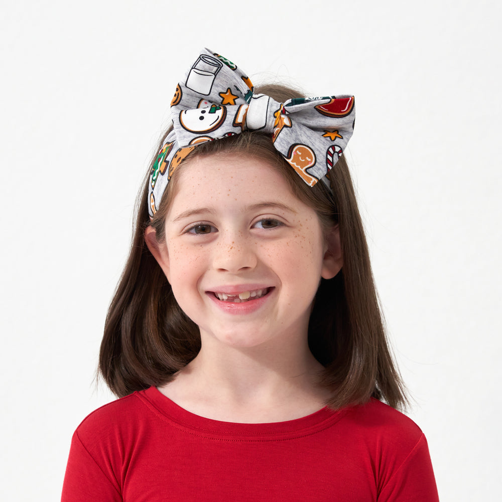 Child wearing a Holiday Treats luxe bow headband paired with a Holiday Red two piece pajama set