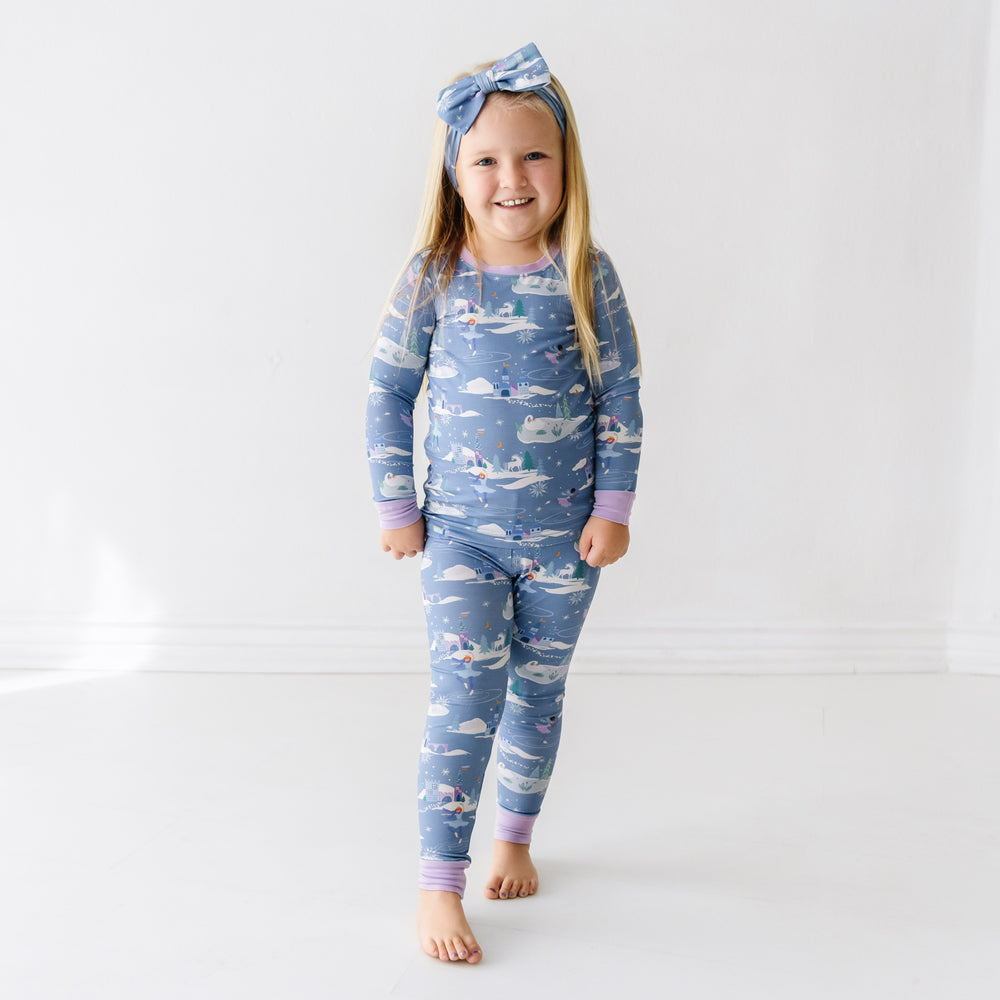 Child wearing an Ice Princess printed two piece pajama set paired with a matching Ice Princess luxe bow headband