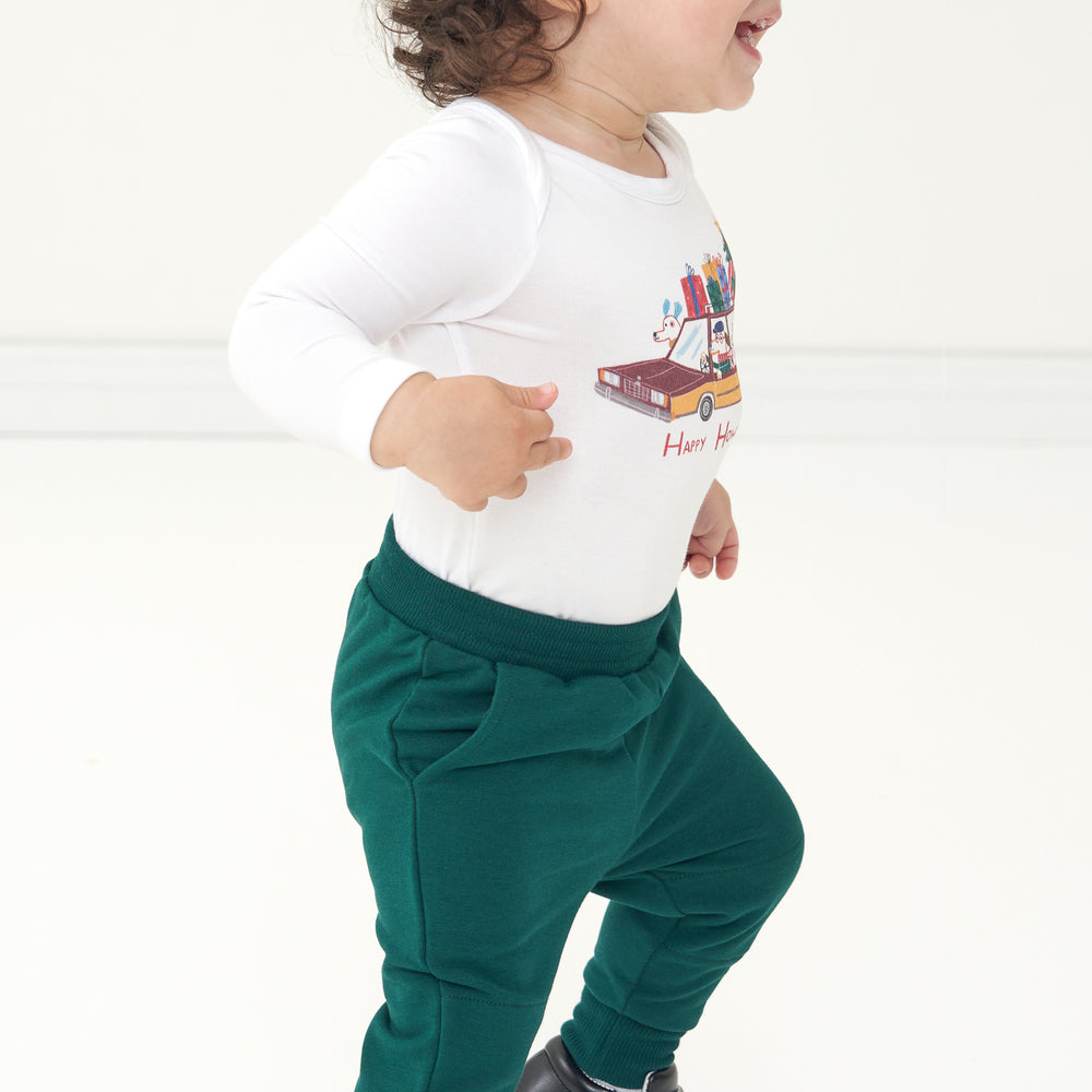 Profile view of a child wearing Emerald Joggers paired with a Happy Howlidays bodysuit
