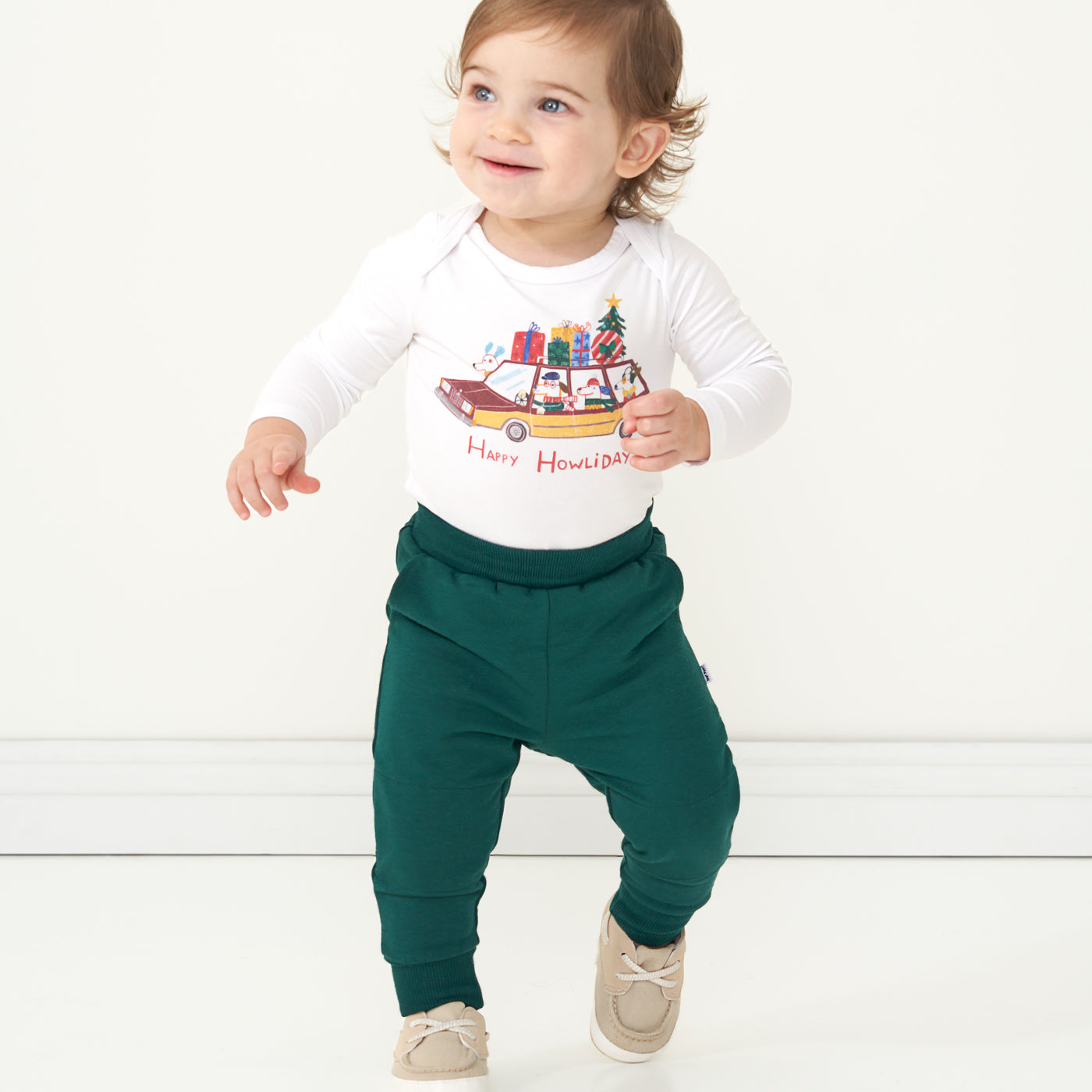 Child wearing Emerald Joggers paired with a Happy Howlidays bodysuit