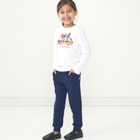 Child wearing Classic Navy joggers and coordinating Happy Howlidays graphic tee