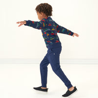 Side view image of a child wearing Classic Navy joggers and a coordinating tree traffic crewneck sweatshirt