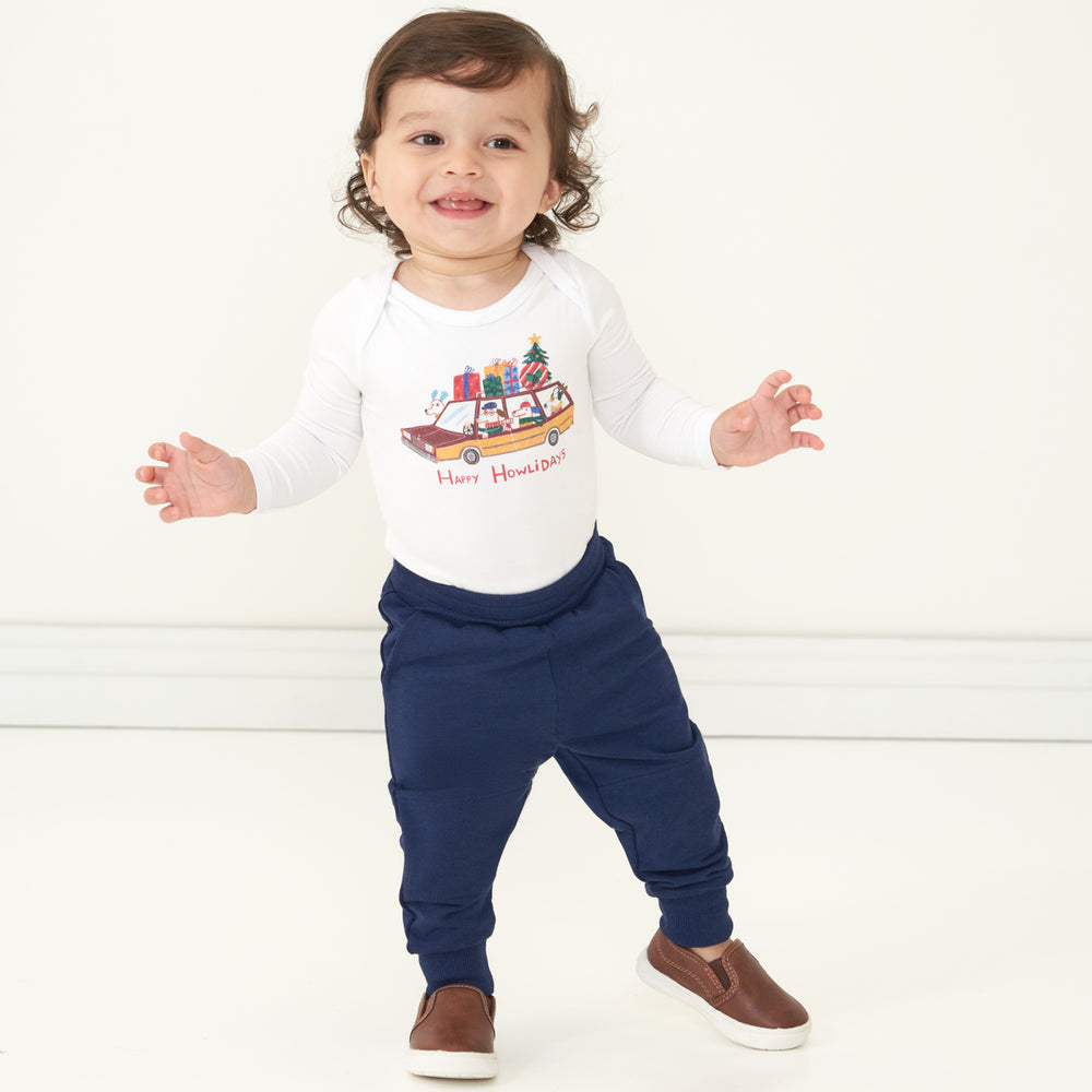Child wearing Classic Navy joggers and a coordinating Happy Howlidays bodysuit