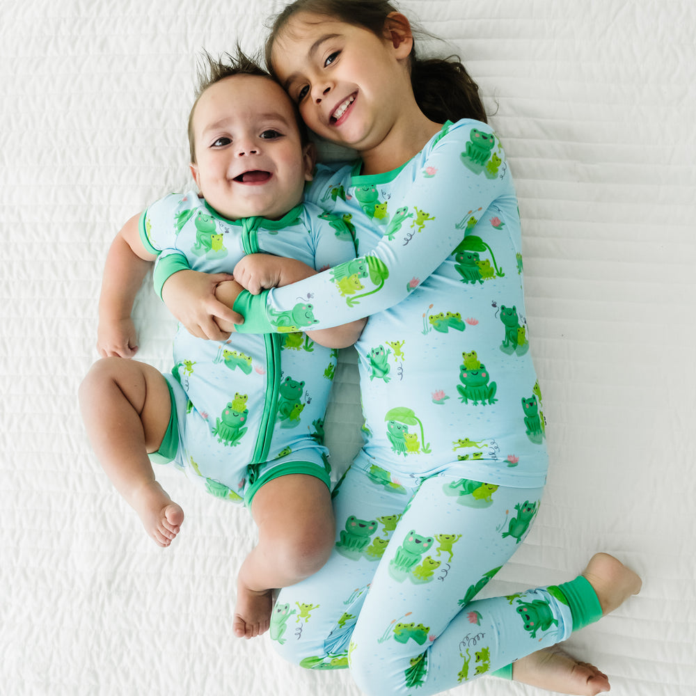 Two children laying on a blanket wearing matching Leaping Love pajamas