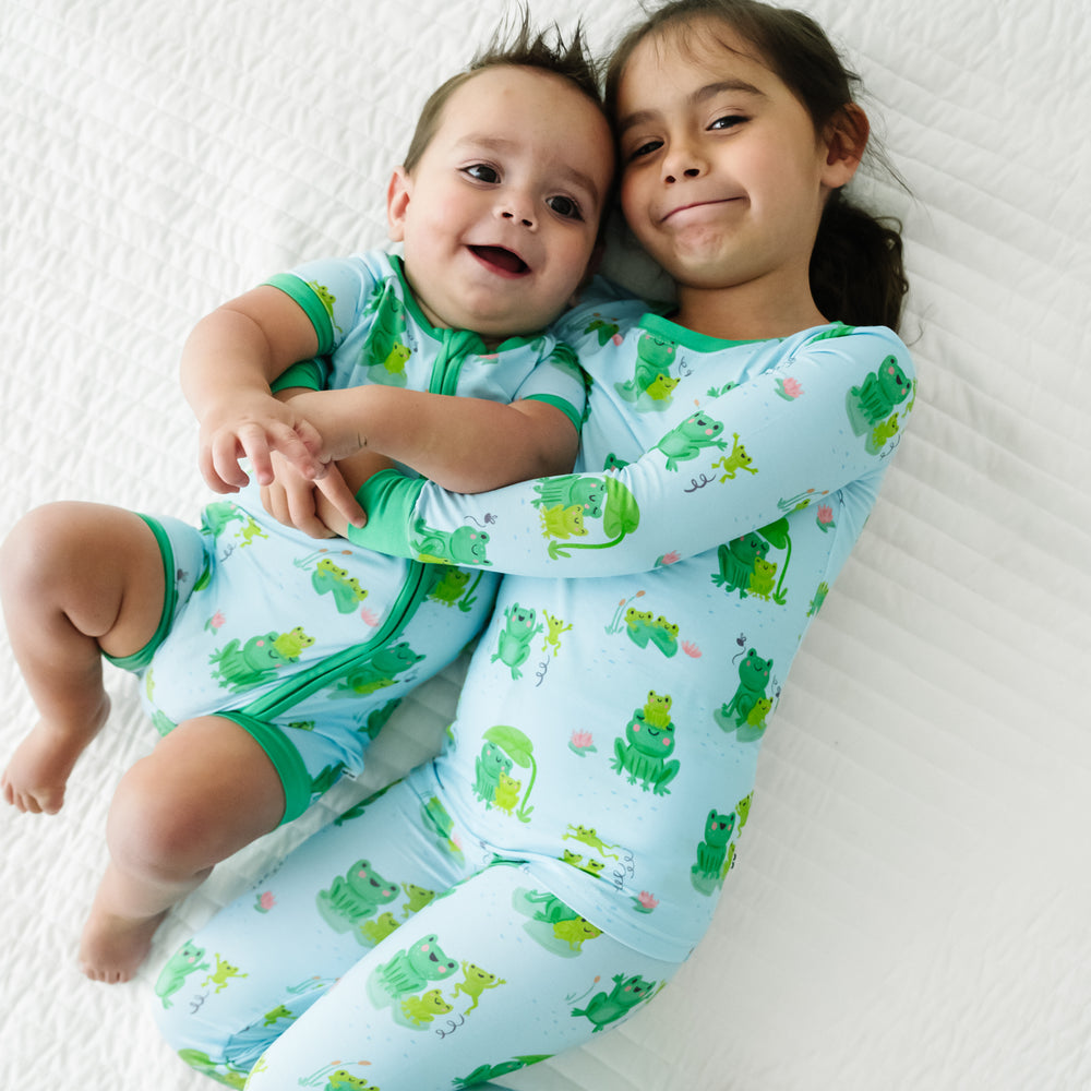 Two children laying on a blanket wearing matching Leaping Love pajamas