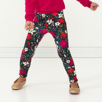 Close up image of a child jumping wearing Berry Merry Leggings paired with an Mixed Berry Pom Pom Sweater