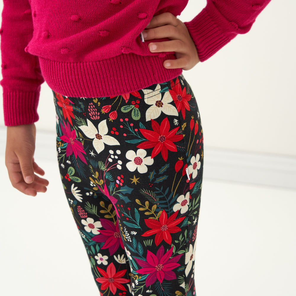 Close up image of a child showing the waistband wearing Berry Merry Leggings paired with an Mixed Berry Pom Pom Sweater