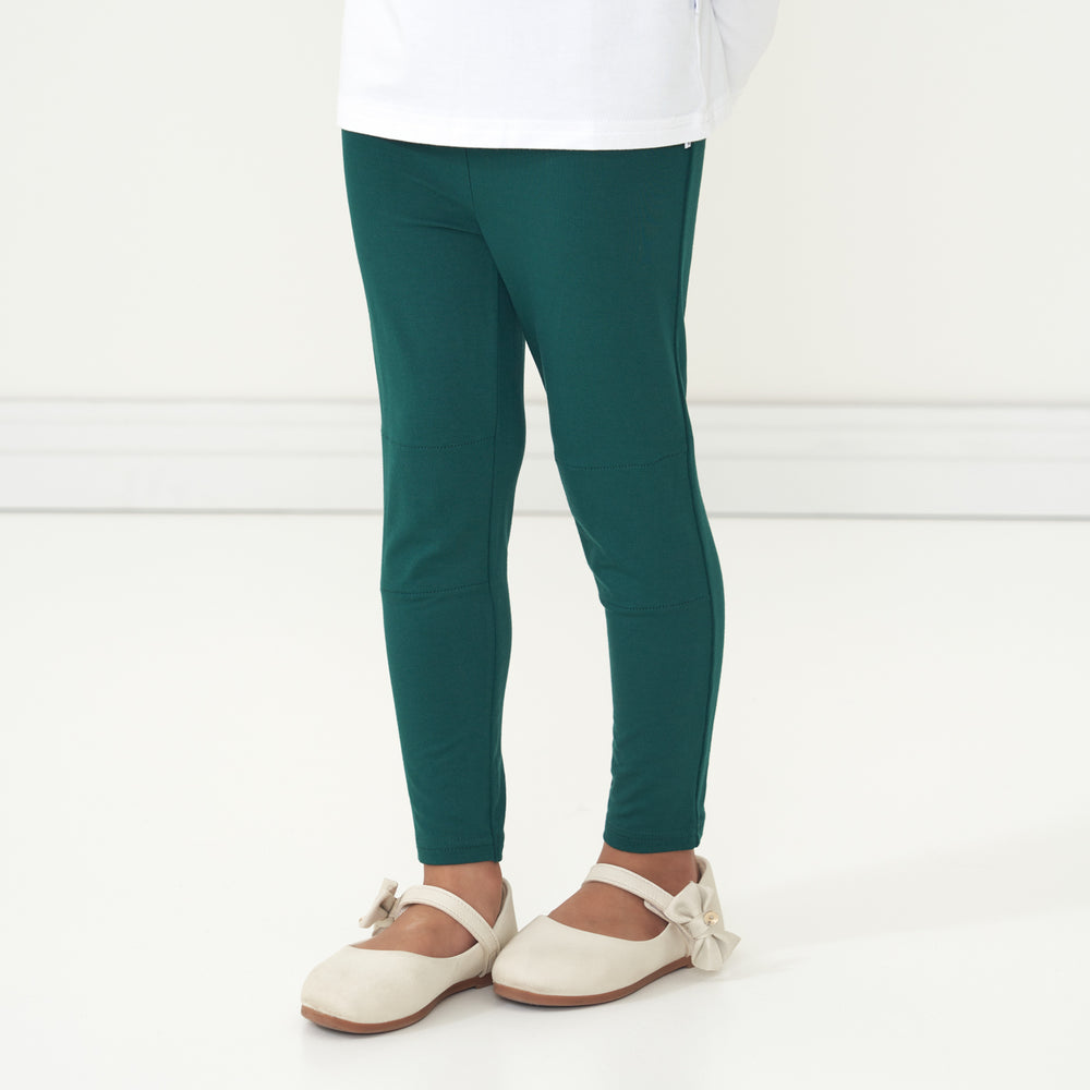 Close up profile image of a child wearing Emerald leggings