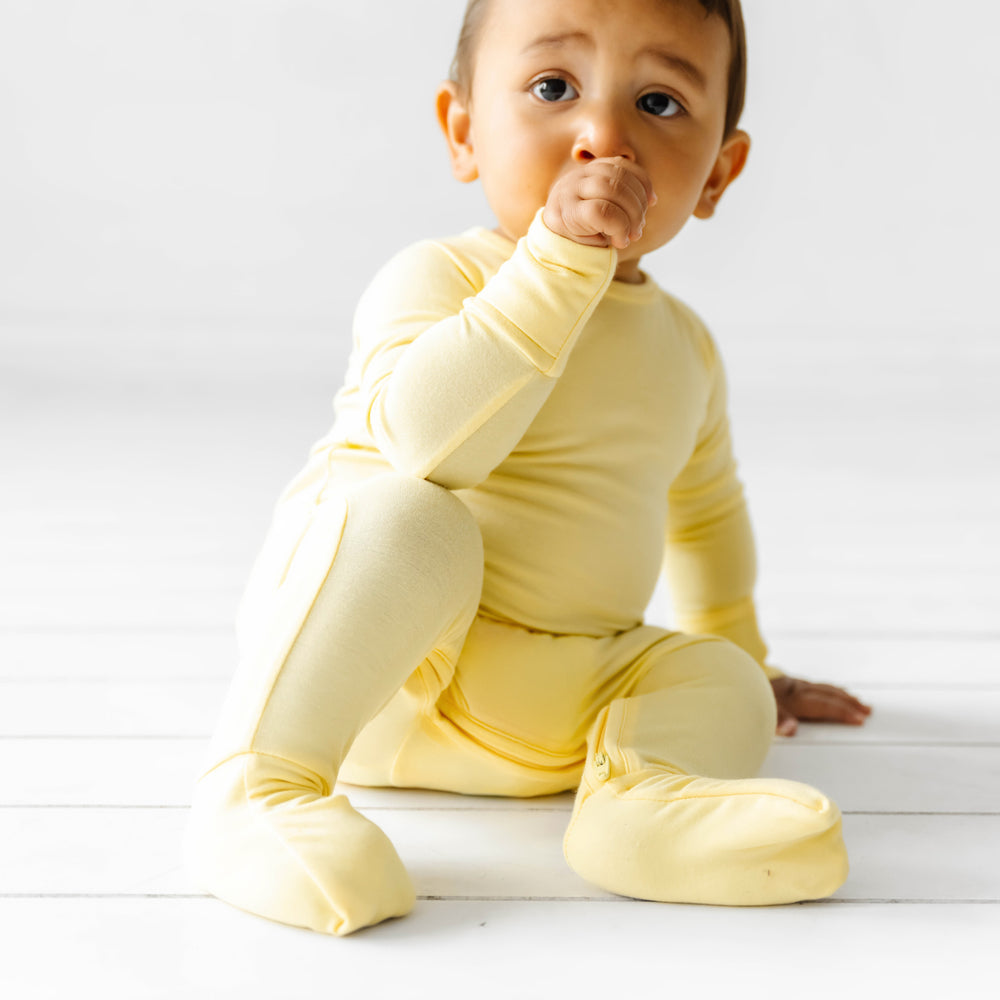 Child sitting wearing a Lemon Twist crescent zippy