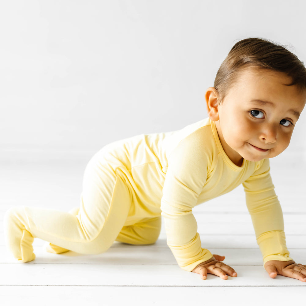 Child crawling towards the camera wearing a Lemon Twist crescent zippy