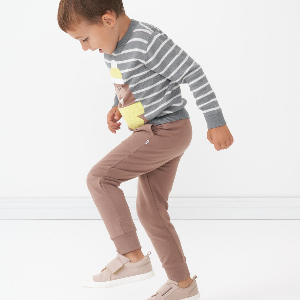 Side view image of a child wearing Light Cocoa joggers and coordinating Walrus knit sweater