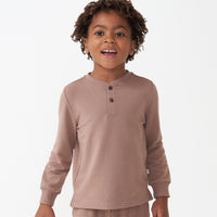 Close up image of a child wearing a Light Cocoa henley tee
