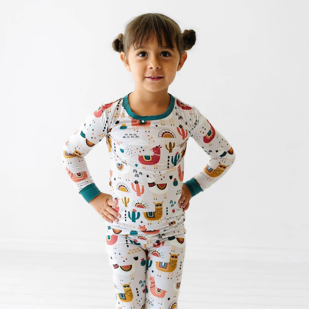 Child standing with their hands on their hips wearing a Llama Love two piece pajama set