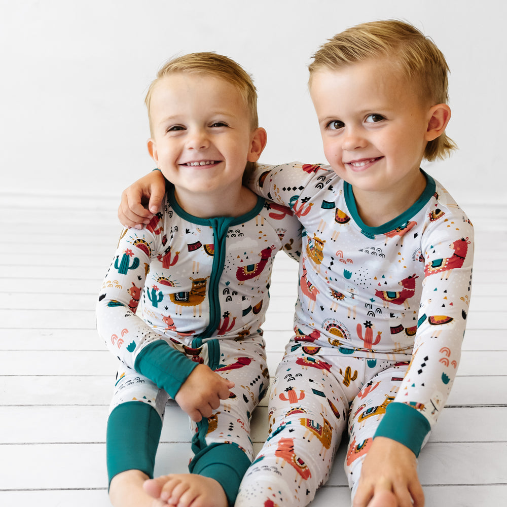 Two children sitting on the ground wearing matching Llama Love pajamas