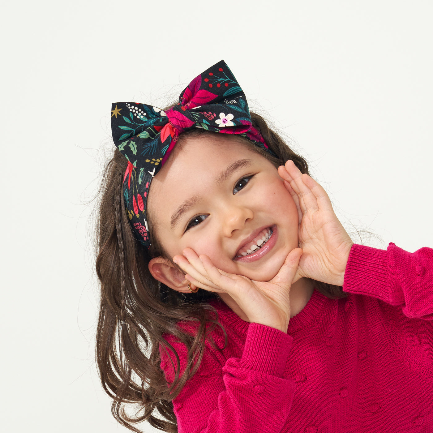 Child posing wearing a Berry Merry luxe bow headband paired with a Mixed Berry Pom Pom sweater