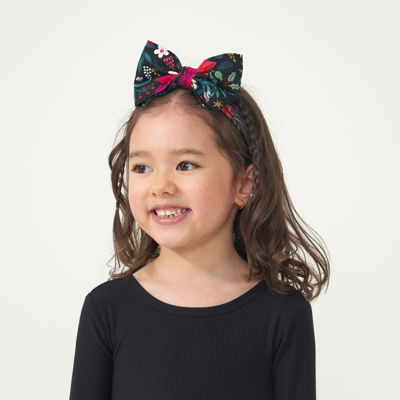 Child wearing a Black Ribbed Twirl dress paired with a Berry Merry Luxe Bow headband 