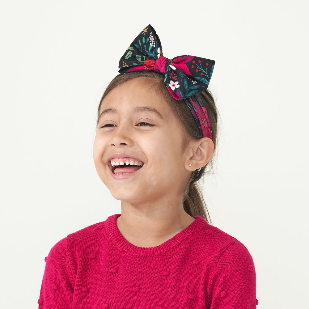 Profile view of a child wearing a Berry Merry luxe bow headband paired with a Mixed Berry Pom Pom sweater