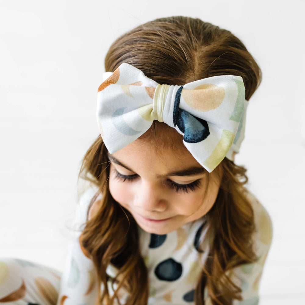 Click to see full screen - Close up image of a child wearing a Luna Neutral luxe bow headband