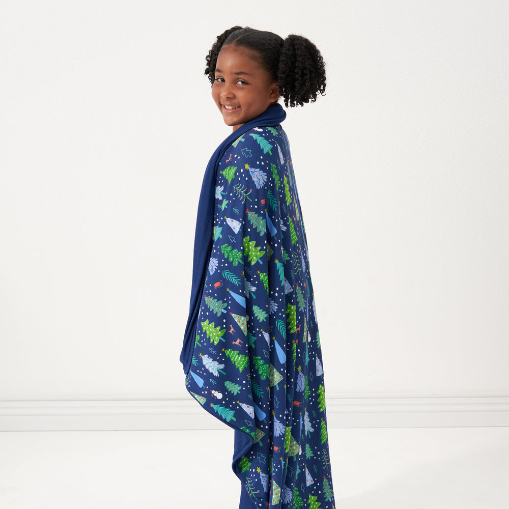Profile image of a child wrapped up in a Blue Merry and Bright cloud blanket