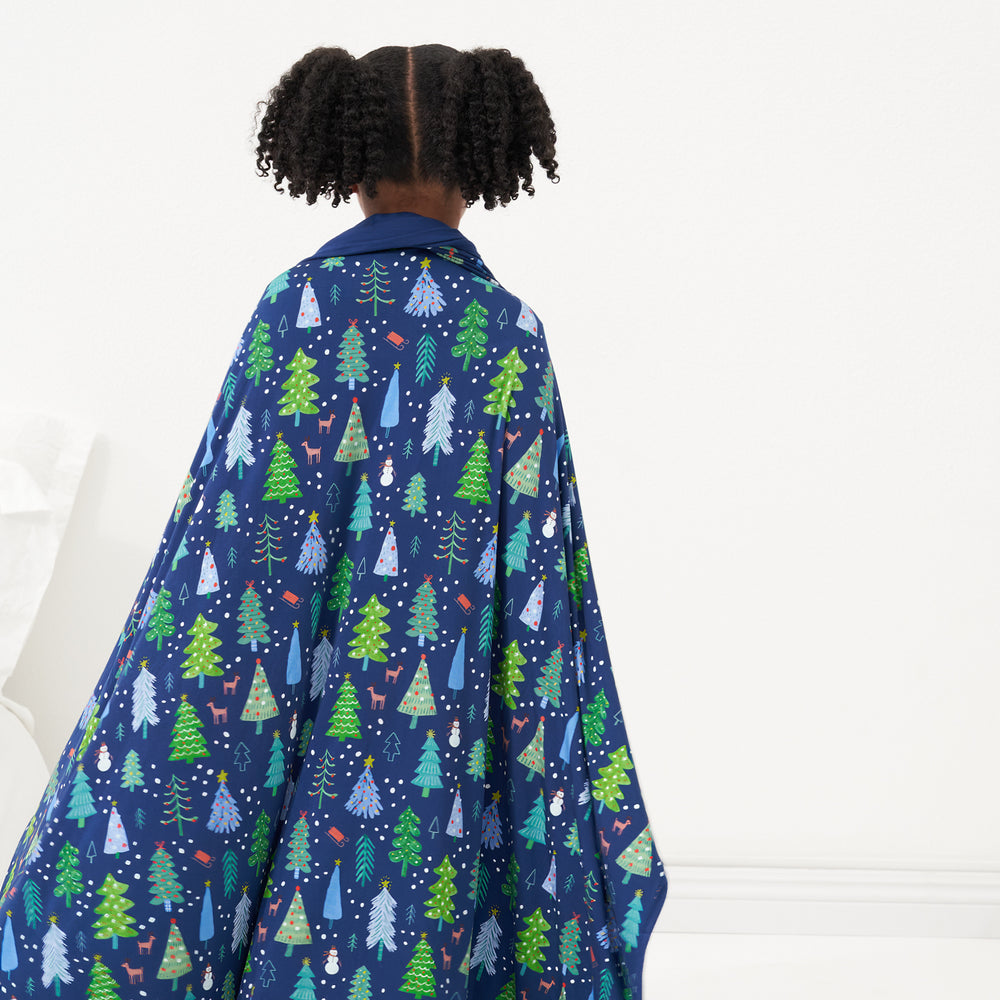 Back view of a child wearing a Blue Merry and Bright cloud blanket around her shoulders