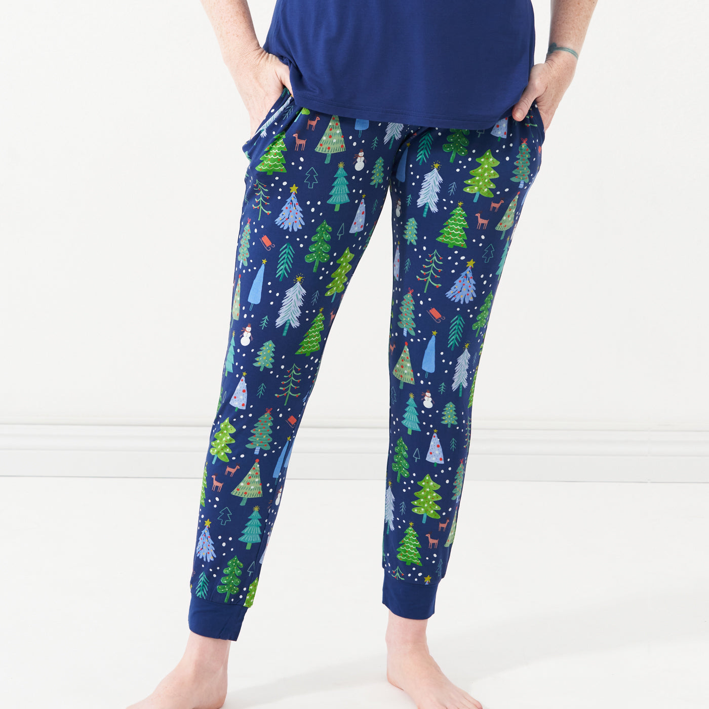 Woman posing with her hands in her pockets wearing Blue Merry and Bright women's pajama bottoms