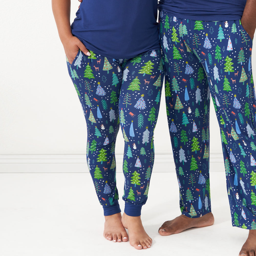 Close up image of a couple posing together wearing matching pajamas. Man is wearing men's Blue Merry and Bright pajama bottoms paired with a solid Sapphire short sleeve pajama top. Woman is wearing women's Blue Merry and Bright pajama bottoms and a solid women's Sapphire short sleeve pajama top