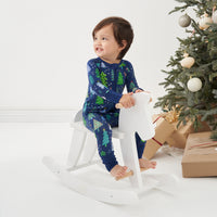 Child sitting on a rocking horse wearing a Blue Merry and Bright zippy