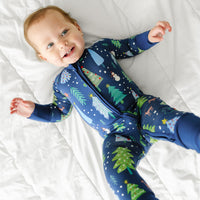 Close up image of a child laying on a bed wearing a Blue Merry and Bright zippy