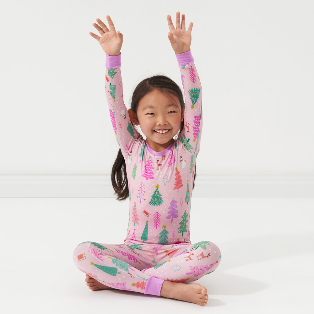 Child posing wearing a Pink Merry and Bright two piece pajama set