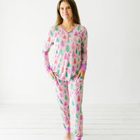 Woman wearing Pink Merry and Bright women's pajama top paired with matching women's pajama pants