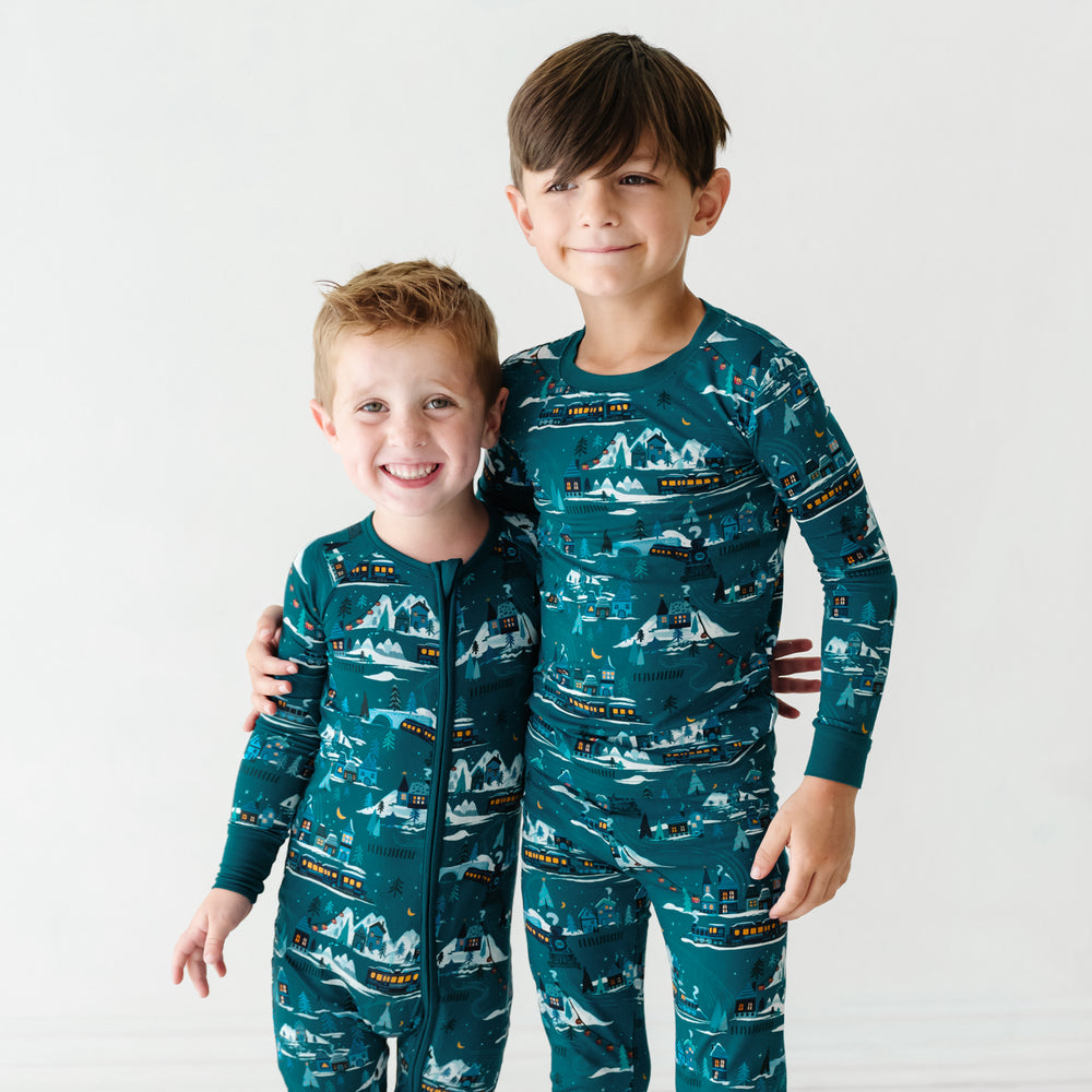 two children posing together wearing Midnight Express pajamas in zippy and two piece set styles