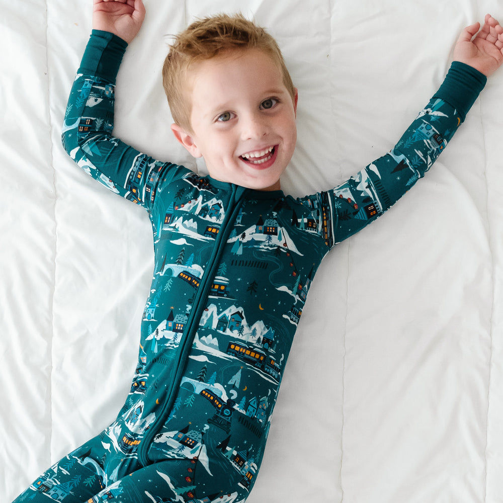 Child laying on a bed wearing a Midnight Express zippy