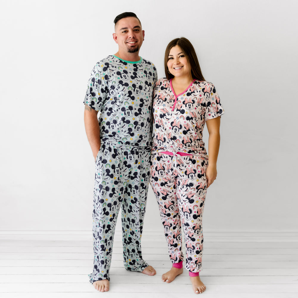 Man and woman wearing coordinating Mickey and Minnie Forever printed pajamas