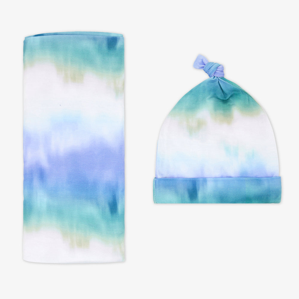 Flat lay of the Blue Cosmic Mist Swaddle & Hat Set