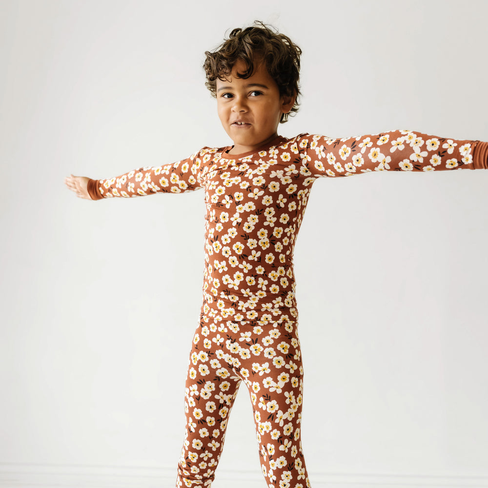 Click to see full screen - Child stretching wearing a Mocha Blossom printed long sleeve pajama set