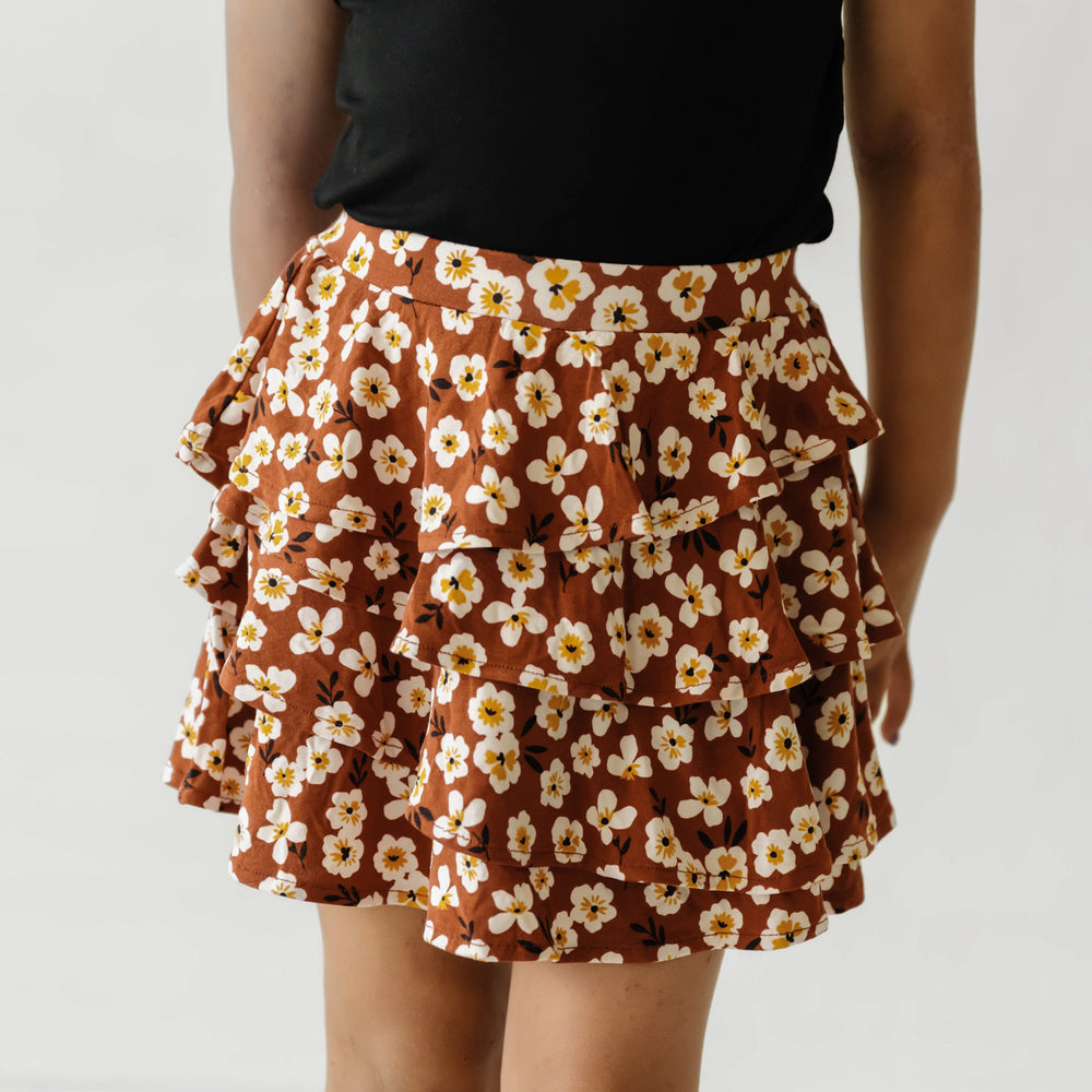 Close up image of a child wearing a Mocha Blossom printed ruffle skort