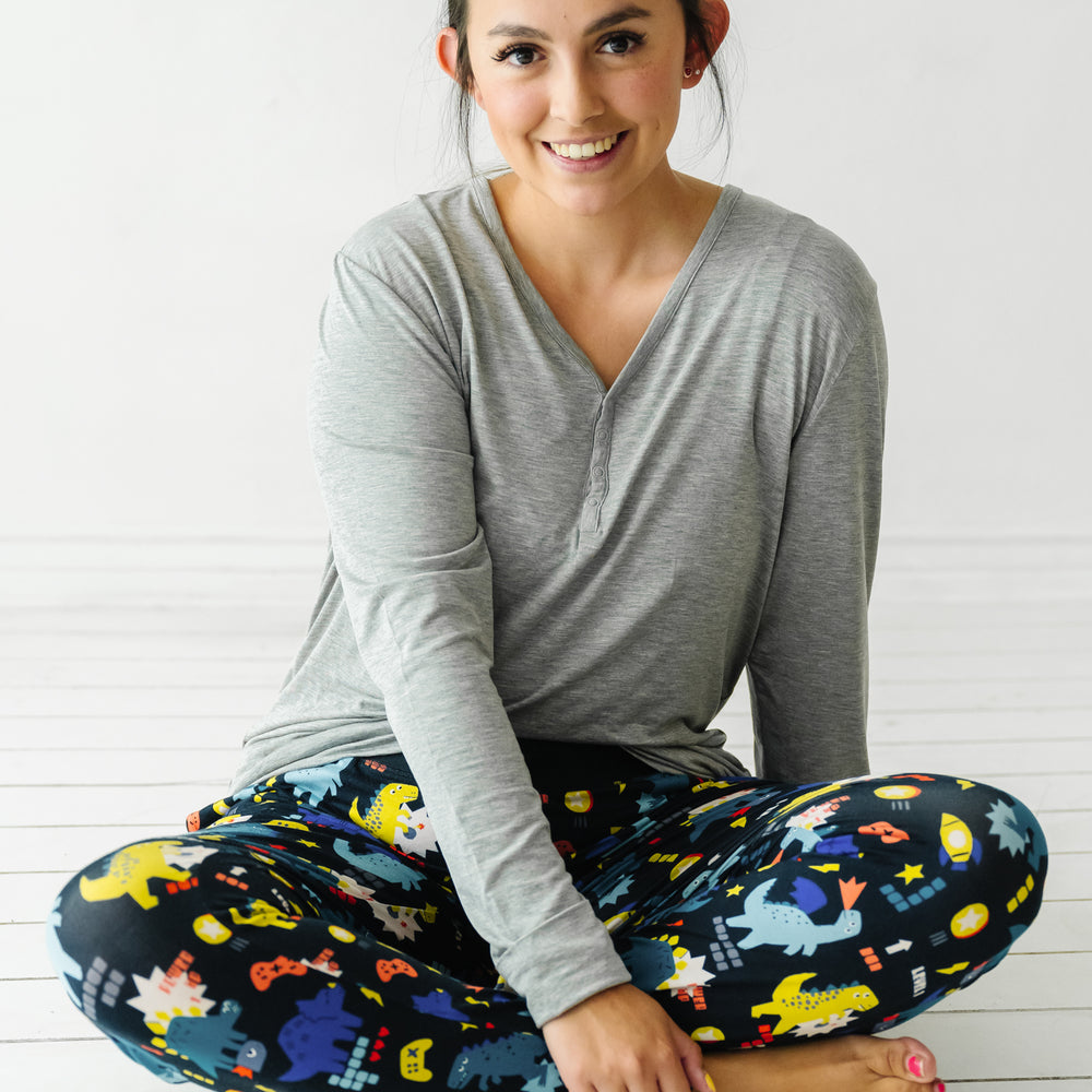 woman posing wearing women's Next Level Dinos pajama pants paired with a coordinating women's Heather Gray pajama top
