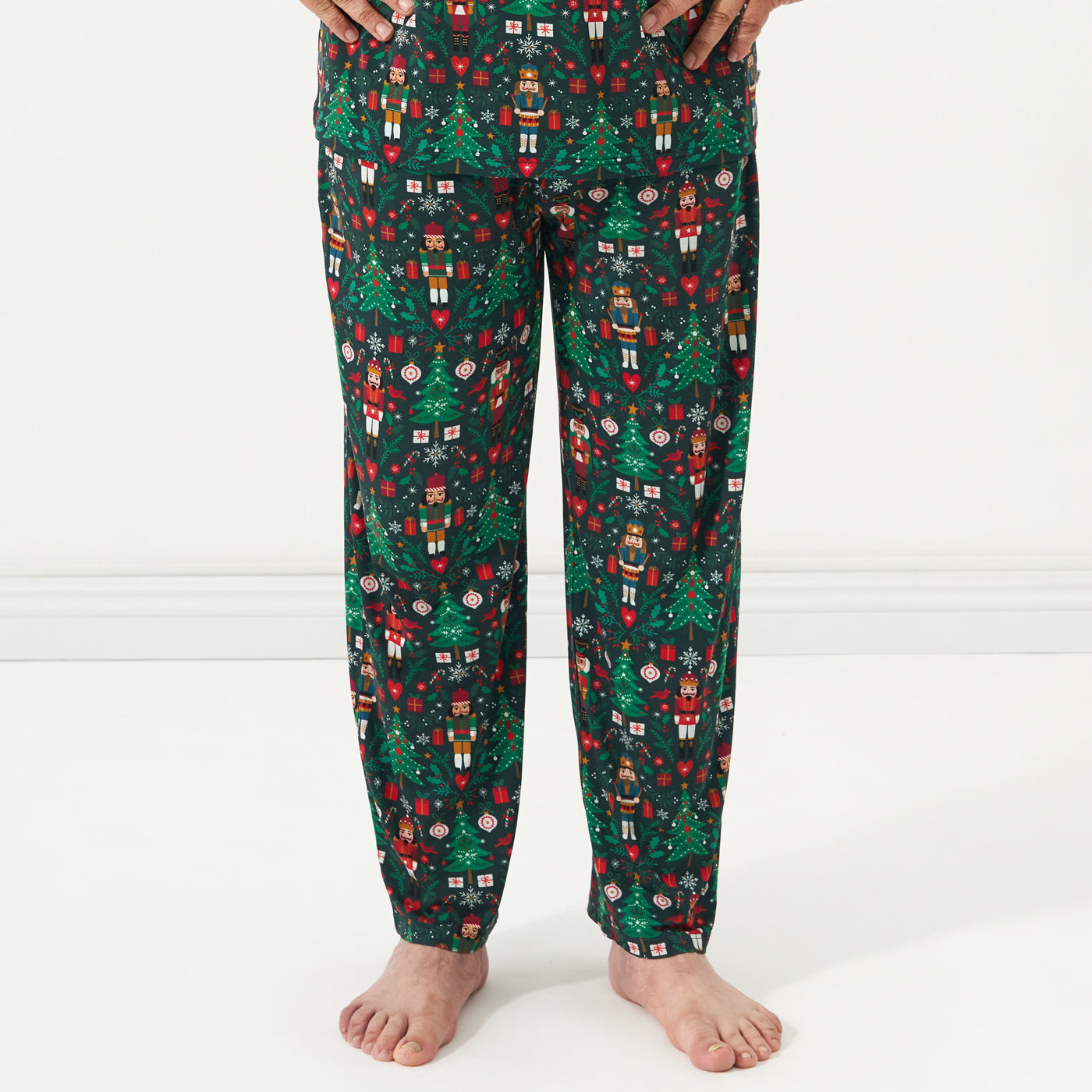 Close up image of a man wearing men's Night at the Nutcracker printed pajama bottoms