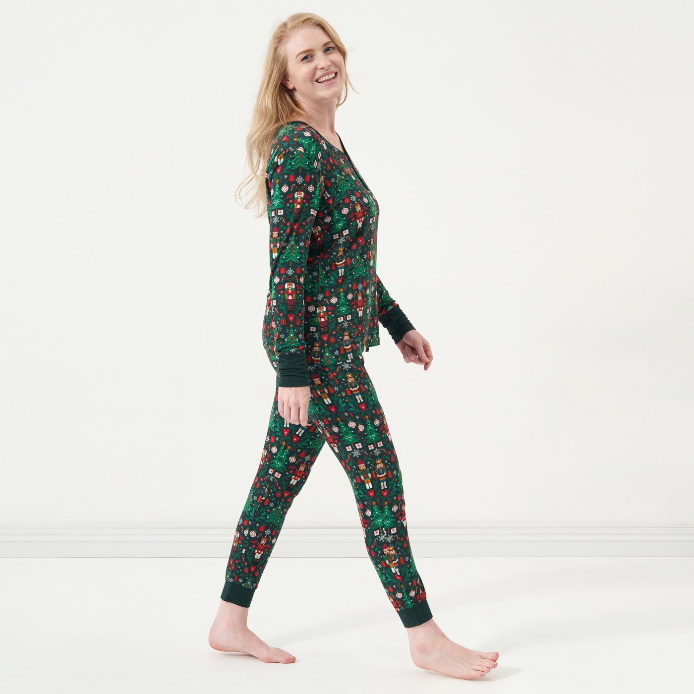 Profile view of a woman wearing Night at the Nutcracker women's pajama top and women's pajama bottoms