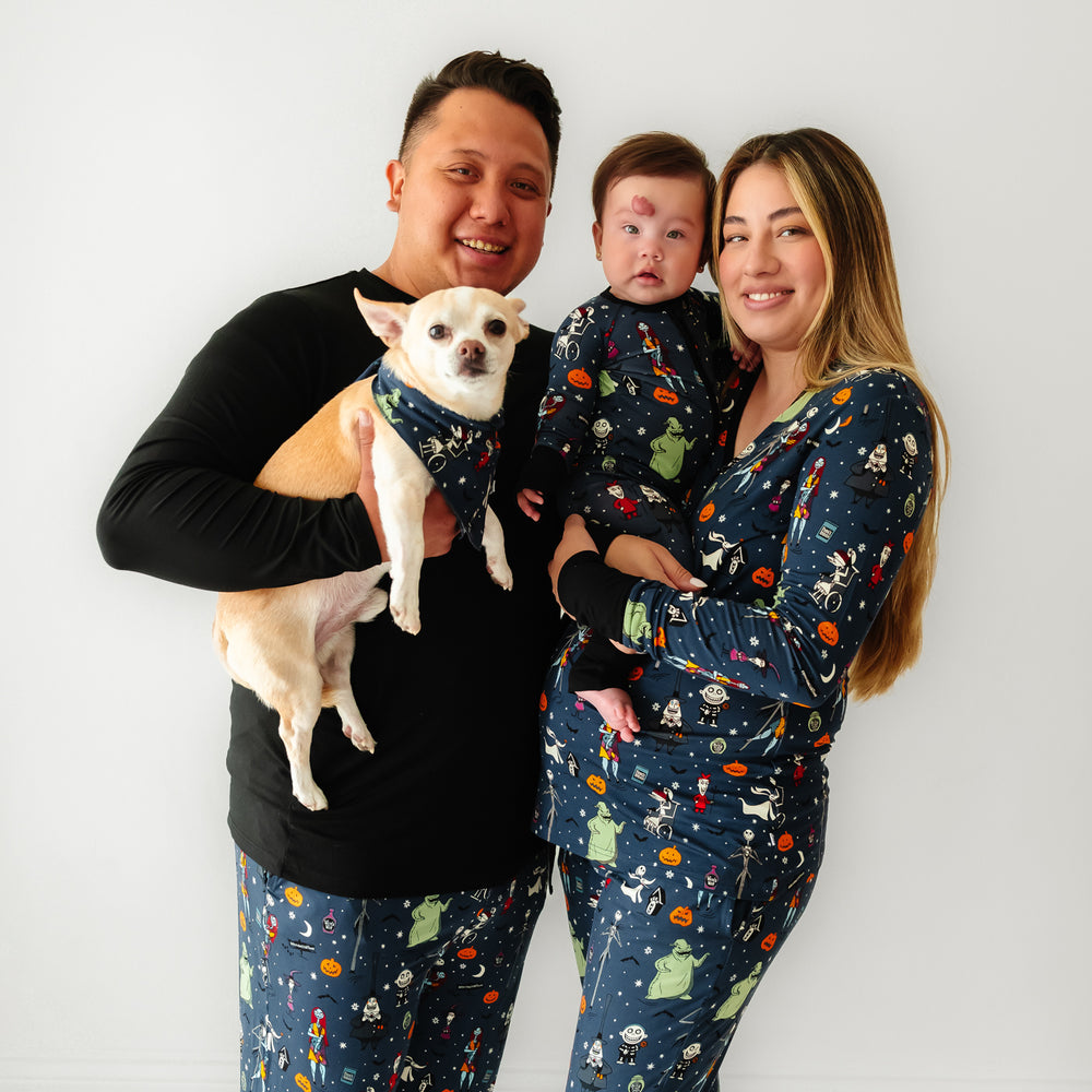 Click to see full screen - Family of three wearing matching Jack Skellington and Friends printed pajamas with their dog wearing a matching pet bandana
