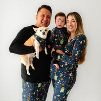 Family of three wearing matching Jack Skellington and Friends printed pajamas with their dog wearing a matching pet bandana