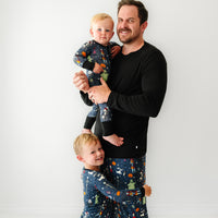 Man and two children wearing matching Jack Skellington and Friends printed pajamas