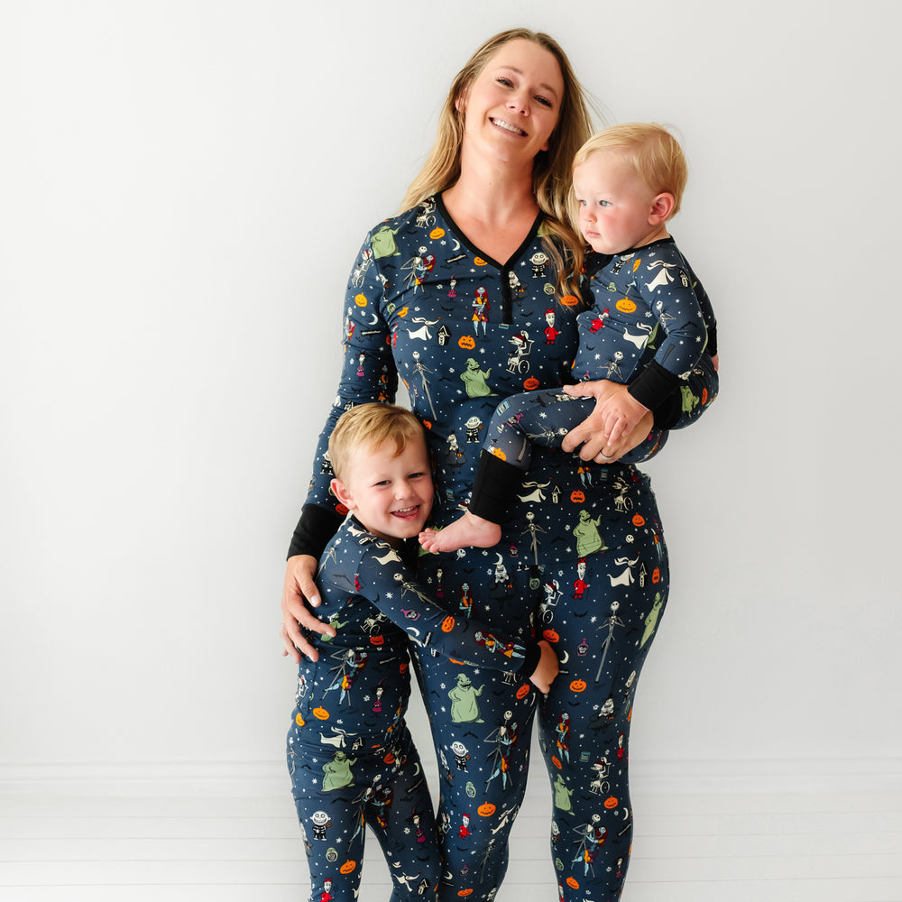 A family of three wearing matching Jack Skellington and Friends printed pajamas